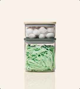 Glass airtight containers stacked with cotton balls and flossers
