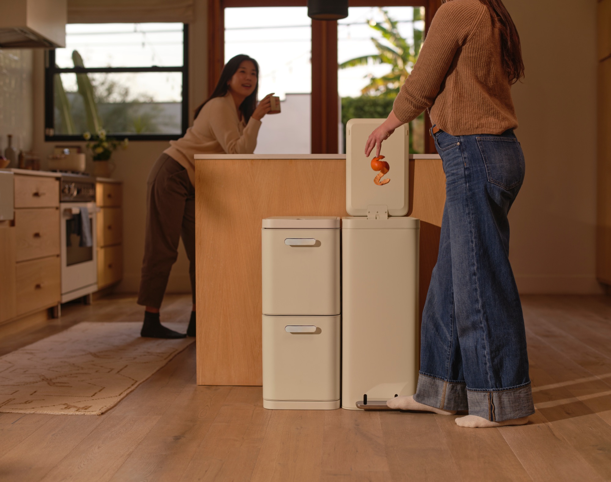 Woman using Caraway trash can step pedal